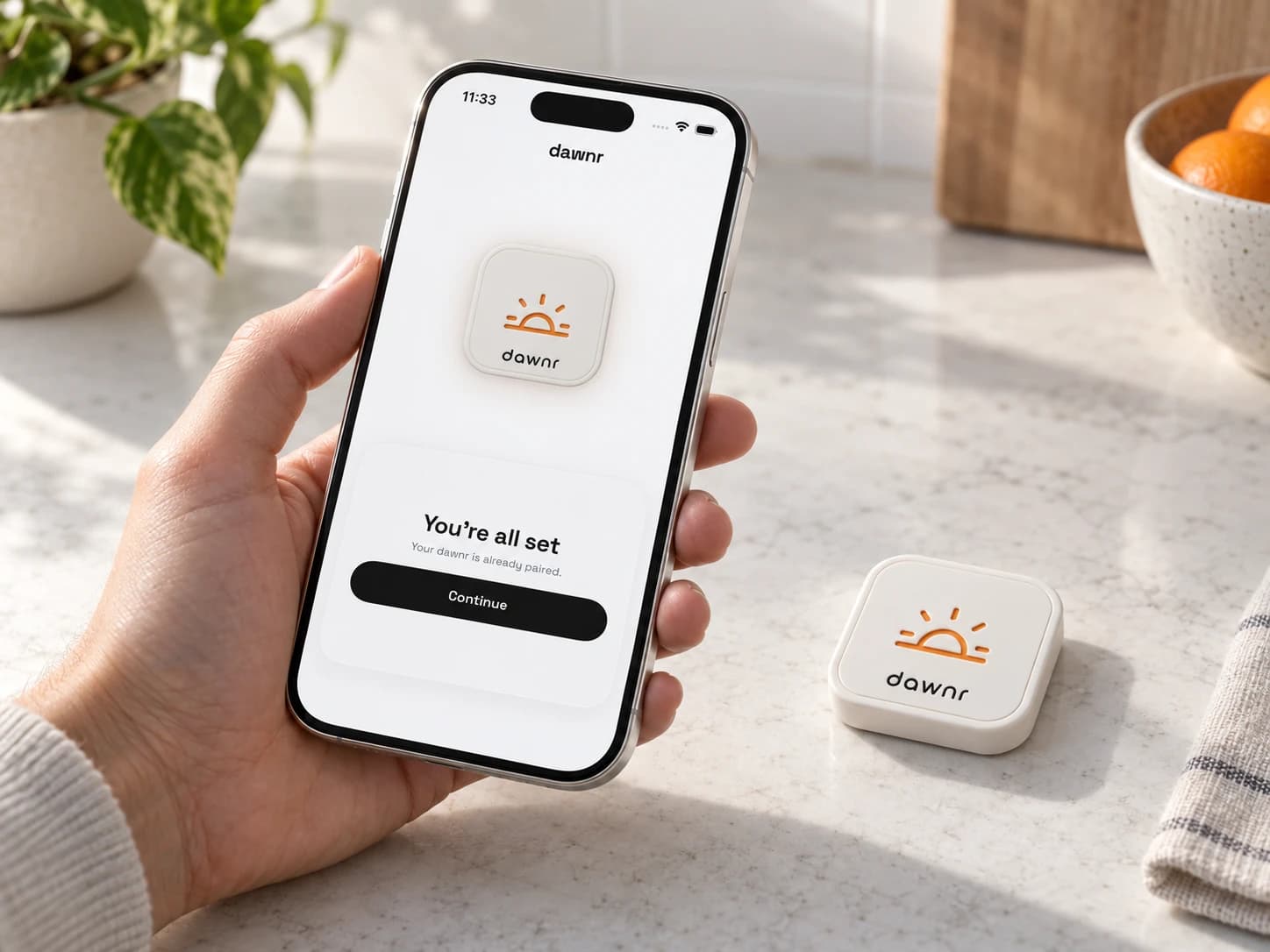 iPhone showing dawnr pairing confirmation beside the device on a kitchen counter