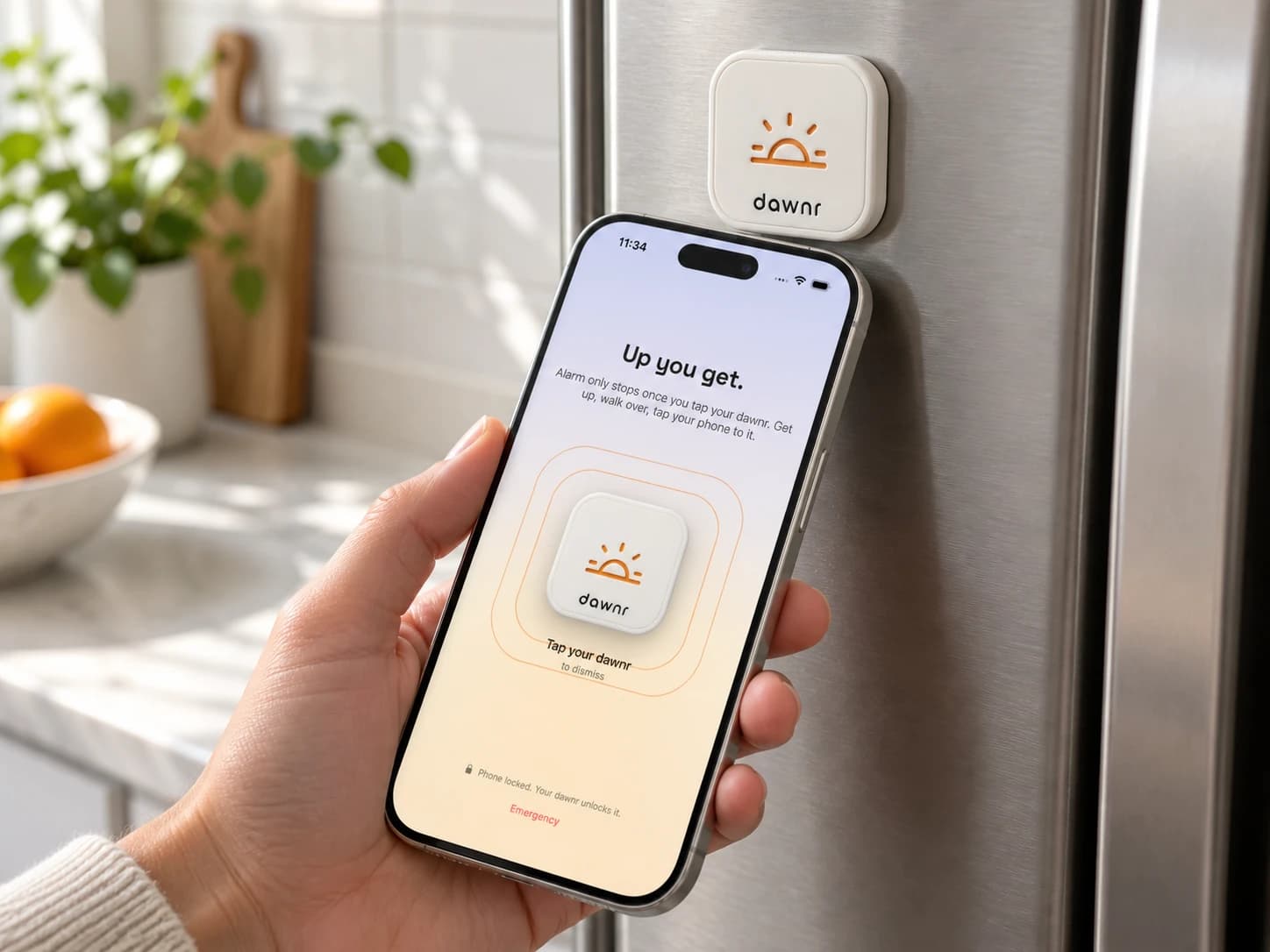 Hand bringing the top of an iPhone toward dawnr on the fridge